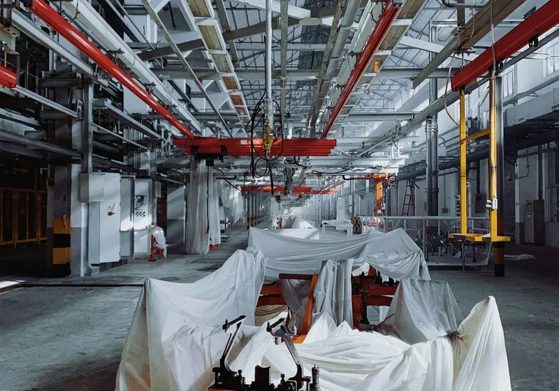 Industrial machinery beneath the steel structure of a manufacturing facility